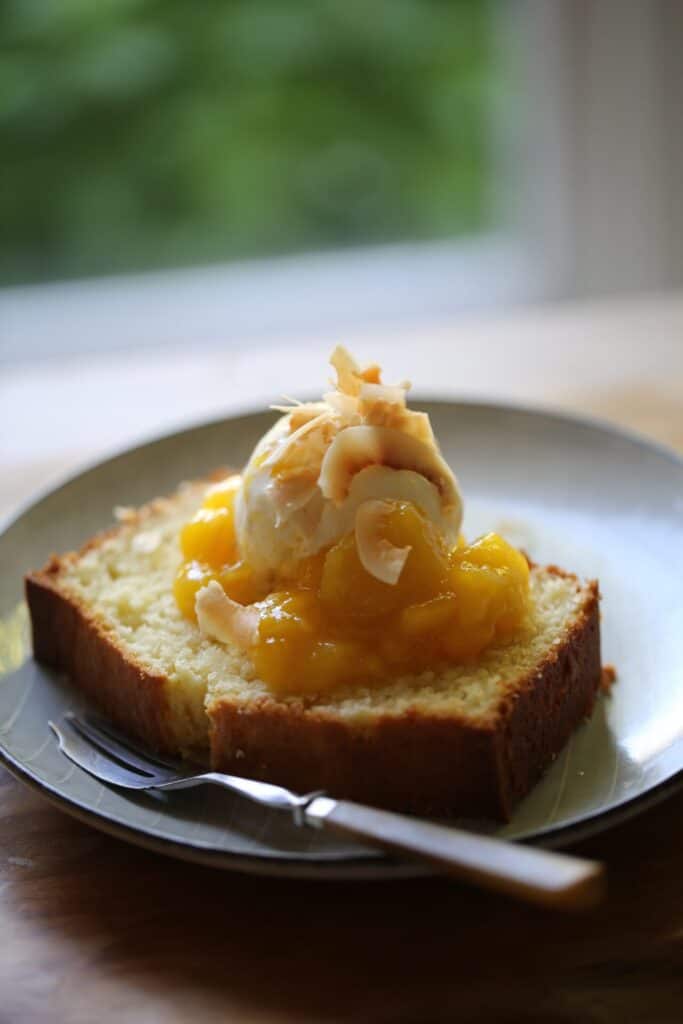 a slice of pound cake with ice cream and mango sauce