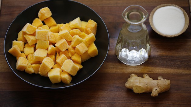 Mangoes, water, ginger and sugar on a cutting board
