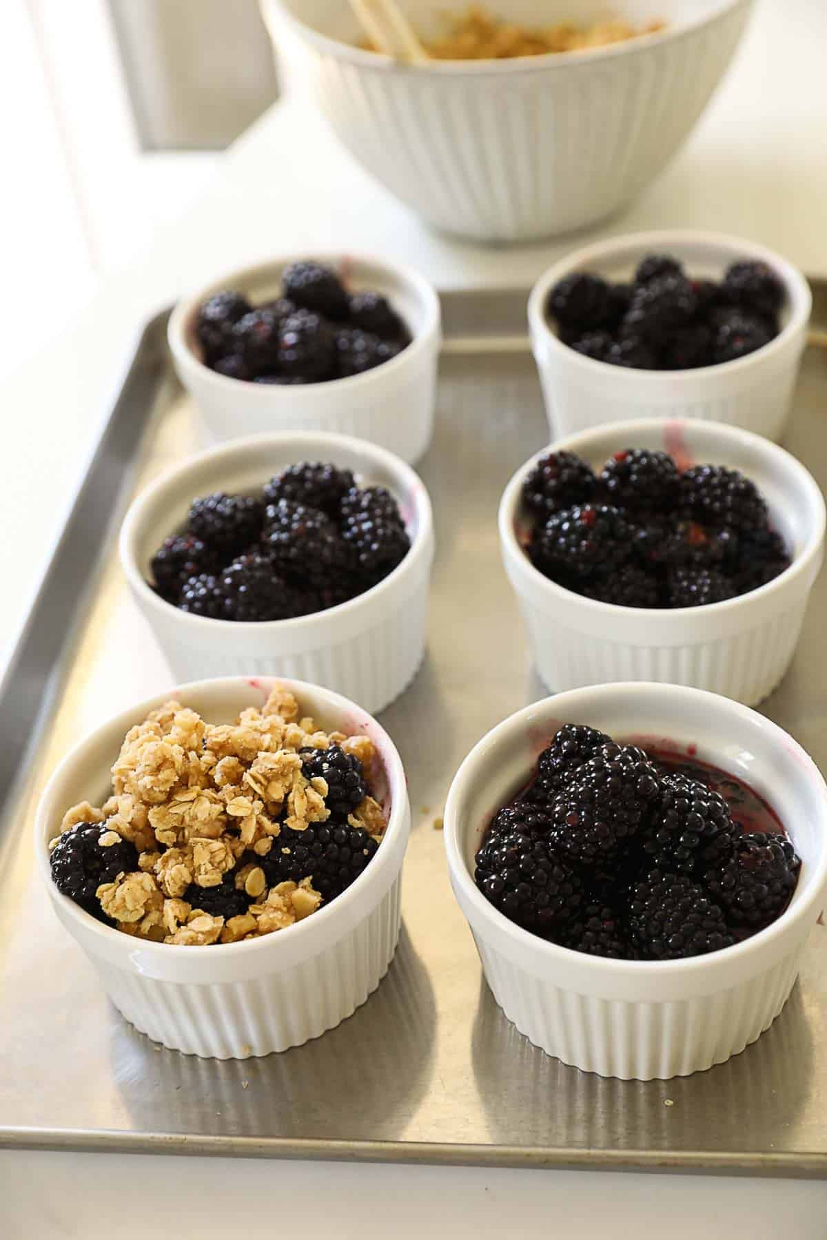 crisp topping covering blackberries in a ramekin.