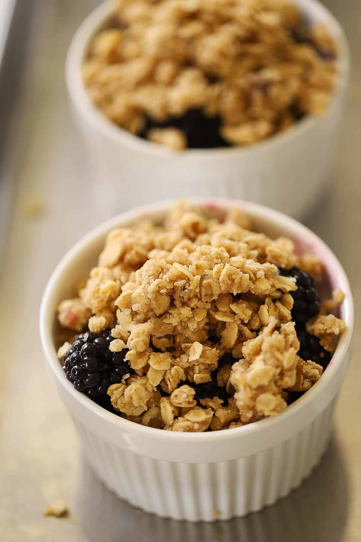 Crisp topping spread over a ramekin of blackberry filling.