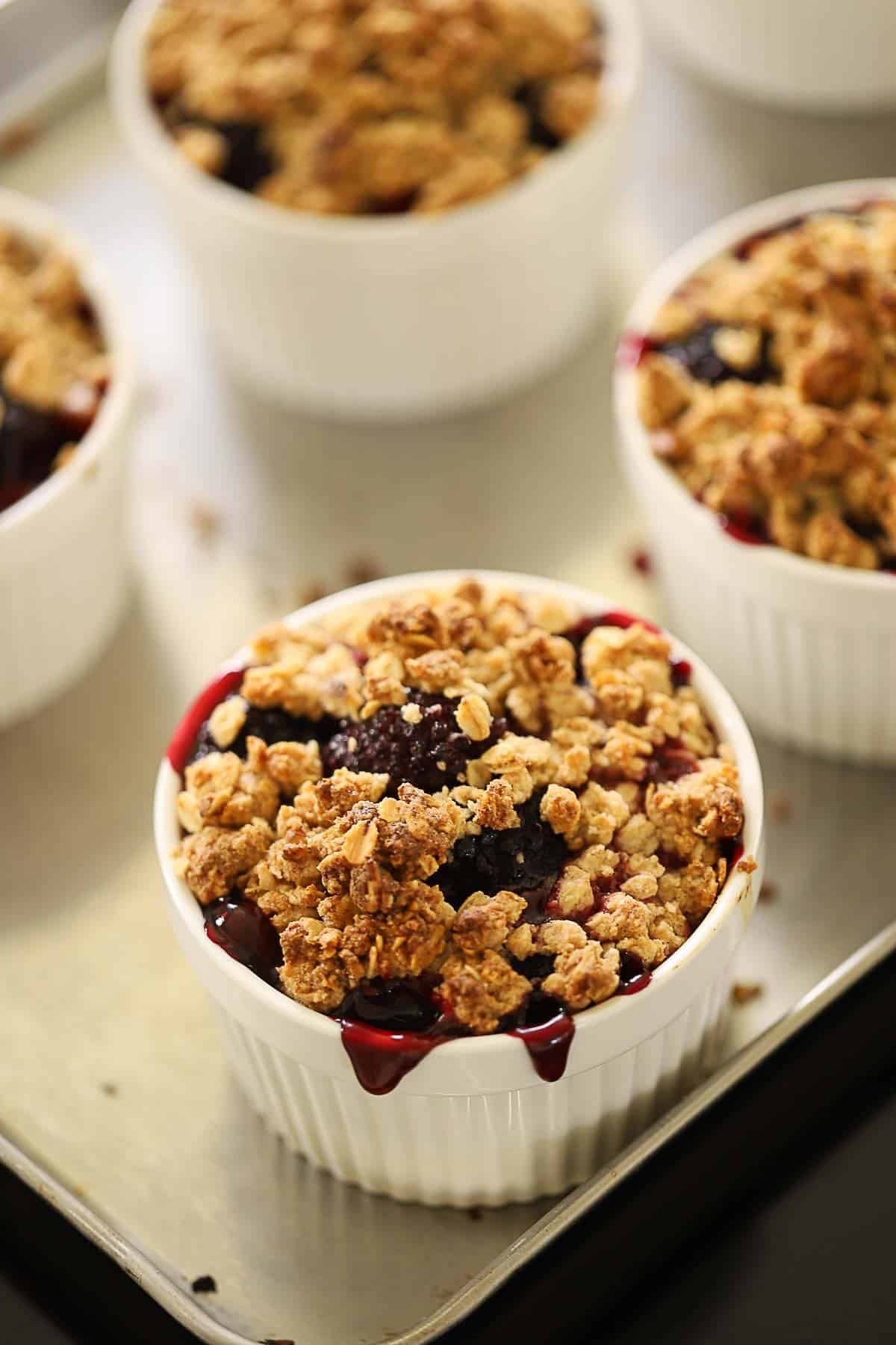Ramekins covered with blackberry drippings and browned crisp topping.