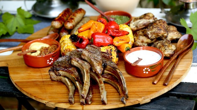 A mixed grill dinner of meat and vegetables on a board