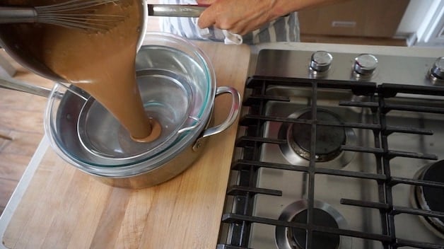 Straining chocolate custard ice cream base through a sieve