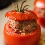 A stuffed tomato with a lid showing a vine rippened tomato.