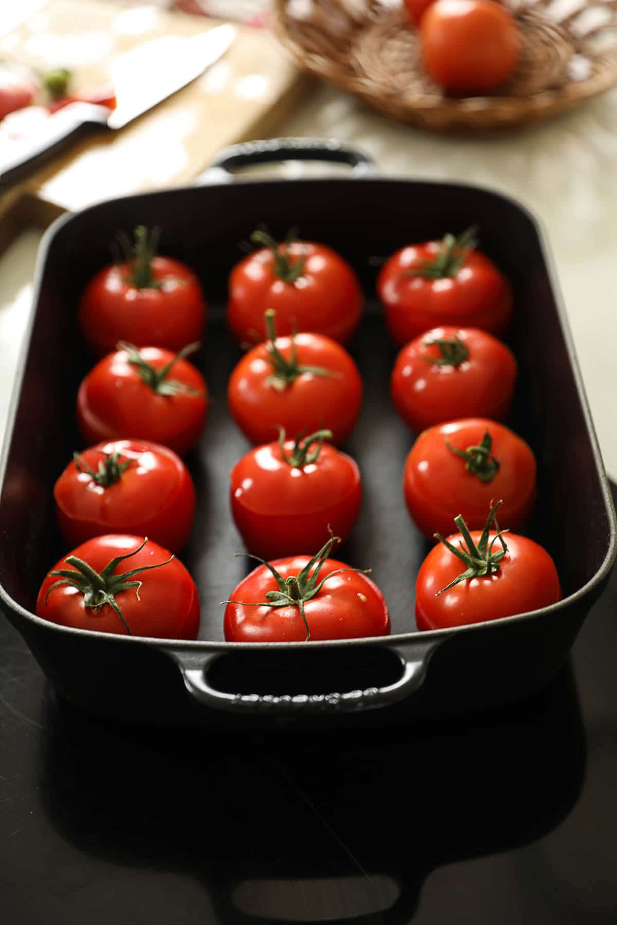 12 tomatoes in a casserole dish before being stuffed.