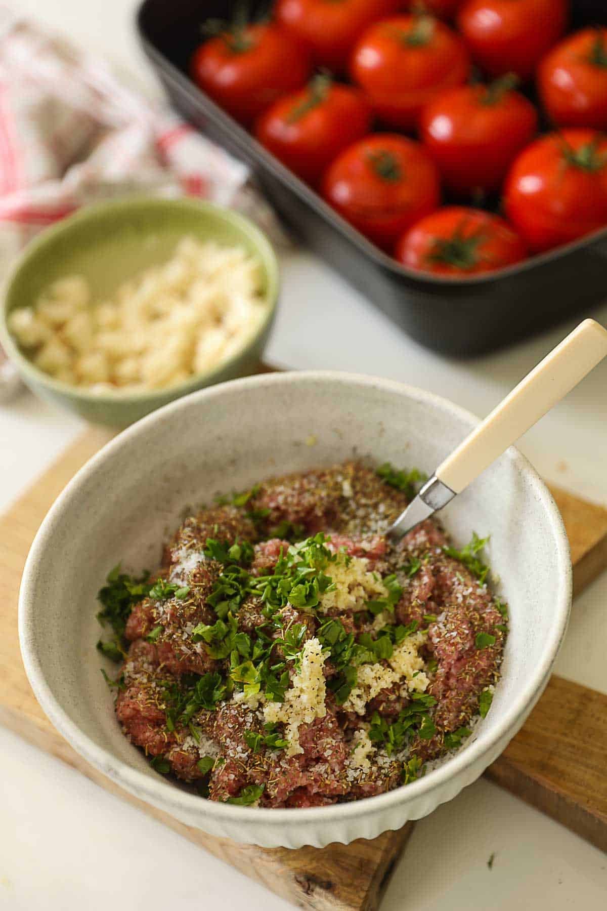 Meat filling in a bowl getting ready to be stuffed into tomatoes.