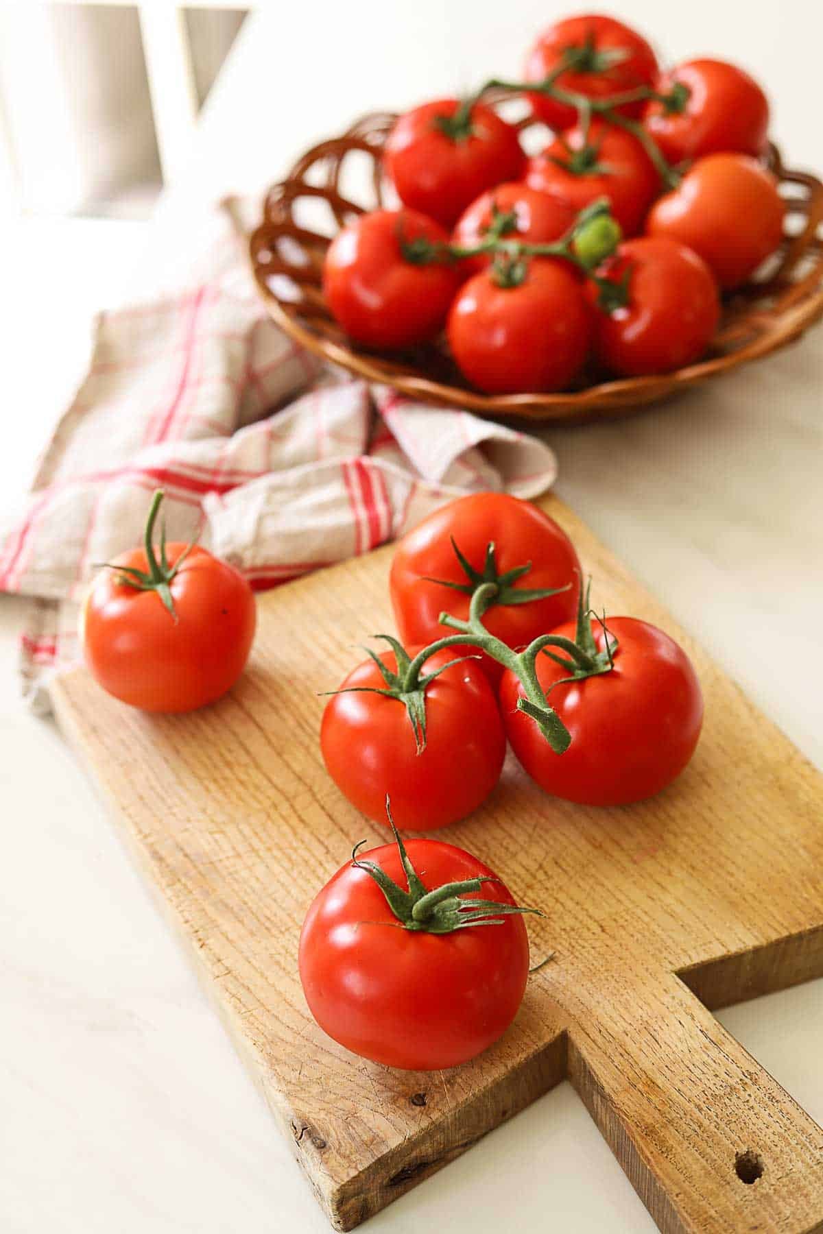 Vine ripened tomatoes on a cutting board.