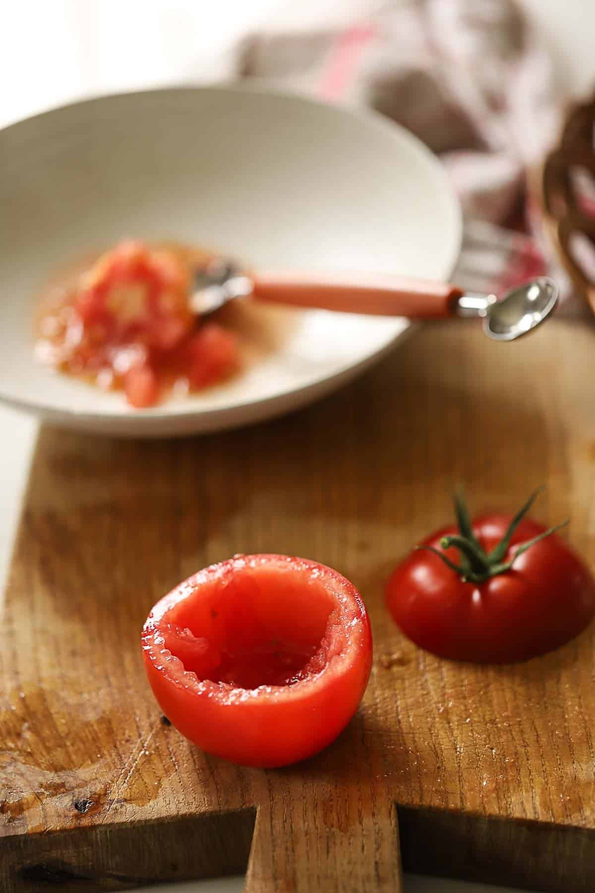 Coring out a tomato with a melon baller.