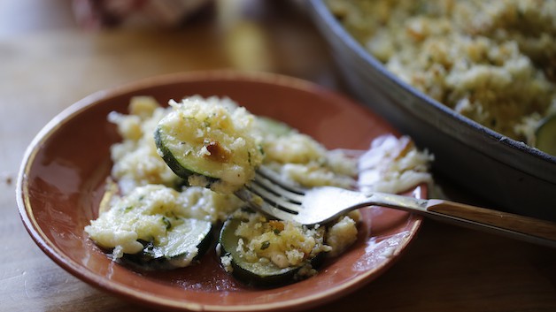 A fork with a bite of zucchini gratin
