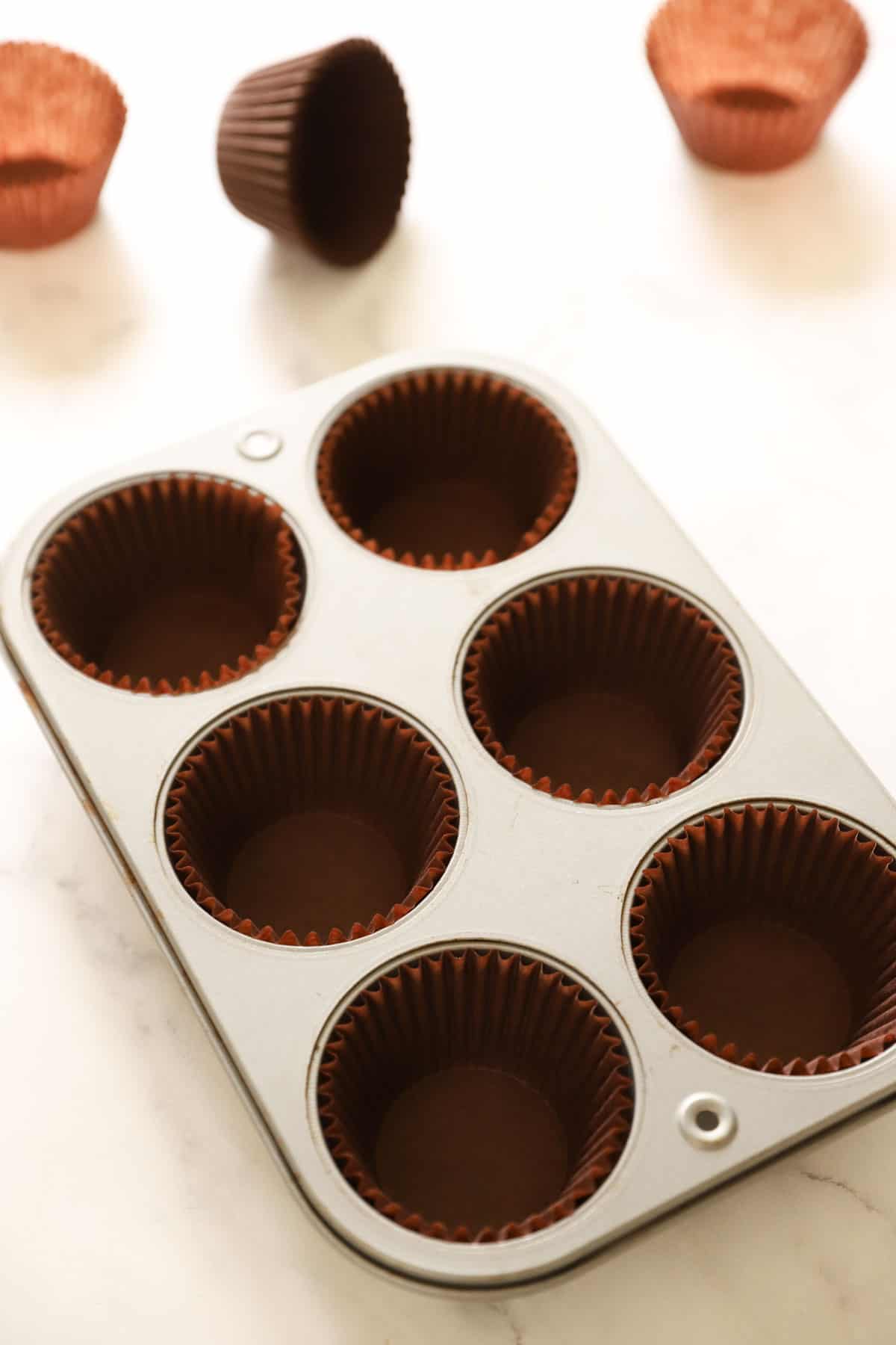 a jumbo muffin tin lined with brown parchment papers