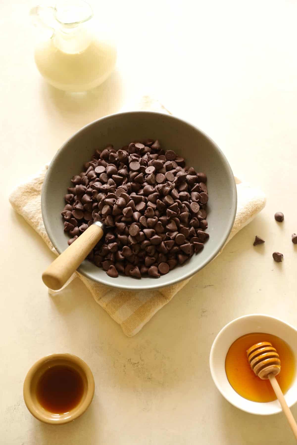 chocolate chips, honey, vanilla and heavy cream laid out on a counter