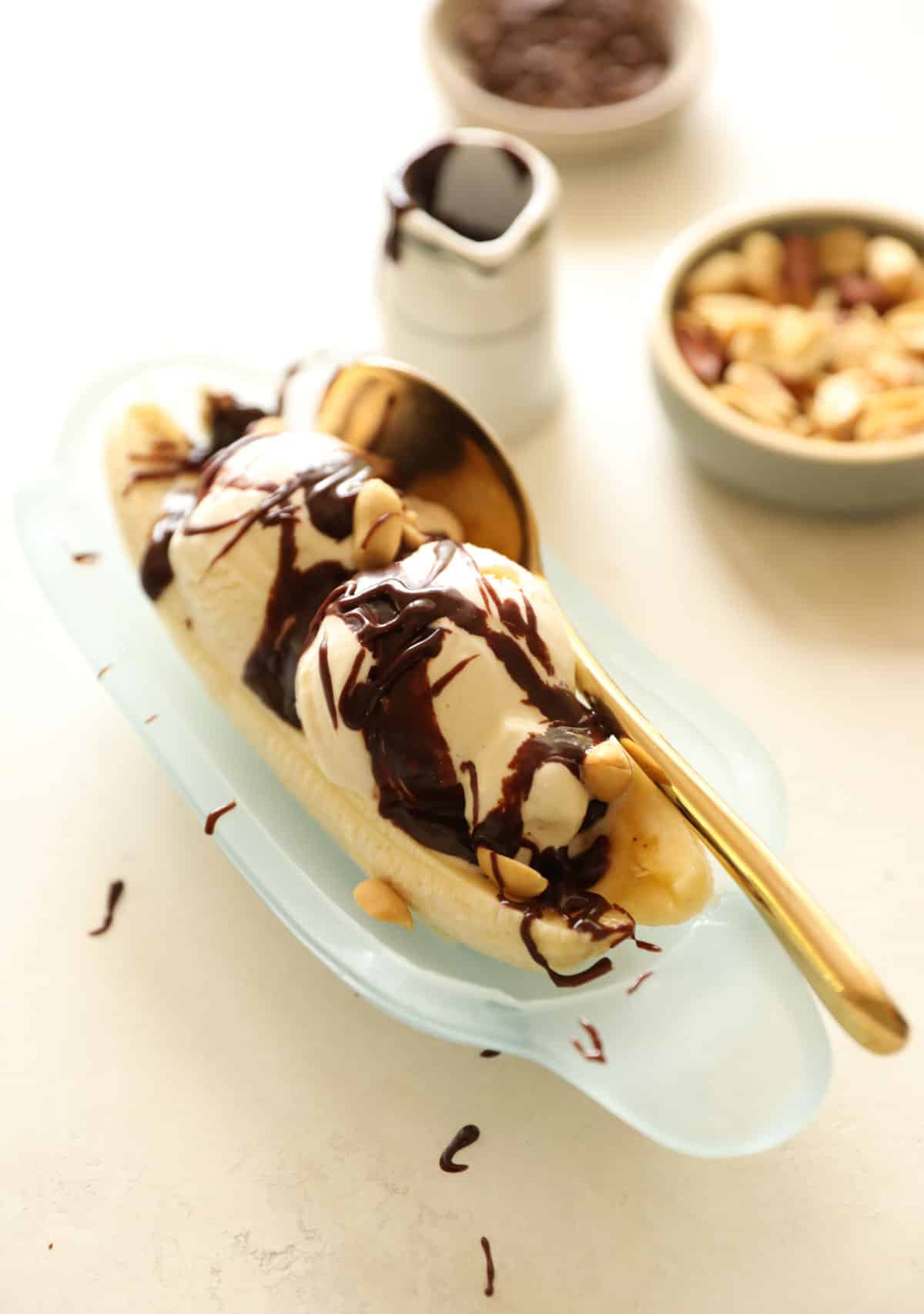 a banana split topped with hot fudge and peanuts on top