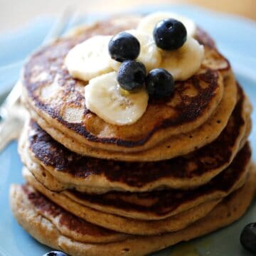 a stack of Oat flour pancakes with blueberries and bananas on a blue plate