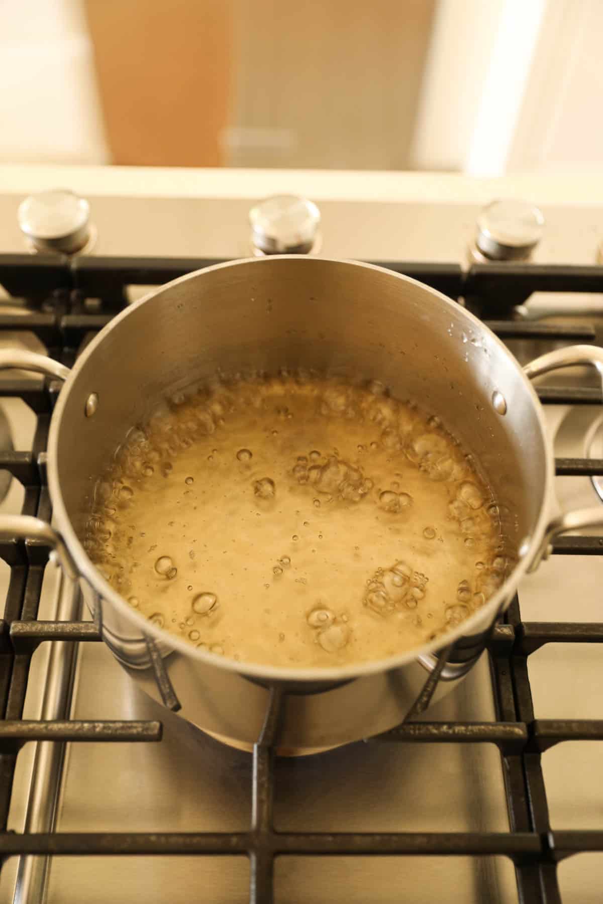sugar water boiling in a pot on a stove