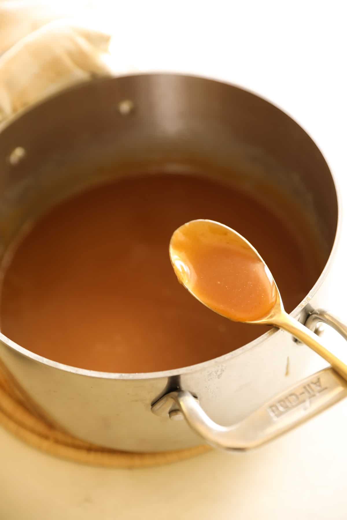 Peanut Butter Ice Cream Sauce in a pot with a gold spoon