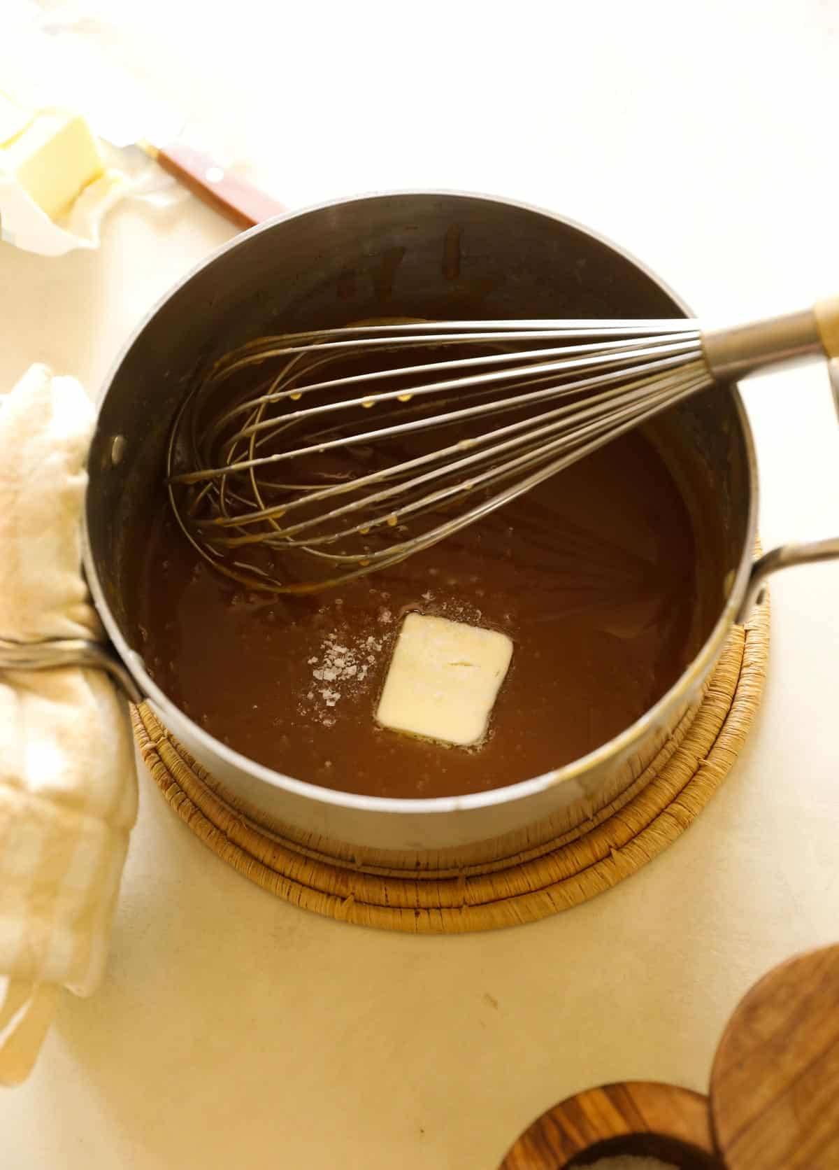 Butter and sea salt in peanut sauce in a pot