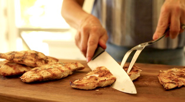 slicing grilled chicken on the diagonal with a chef knife 