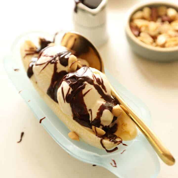 A banana boat with an ice cream sundae topped with hot fudge