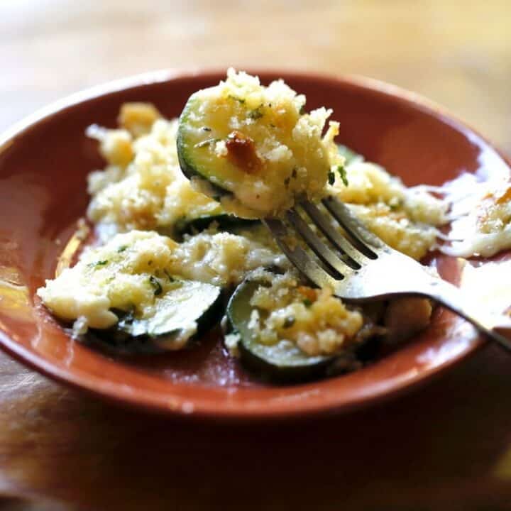 a fork taking a bite of zucchini gratin