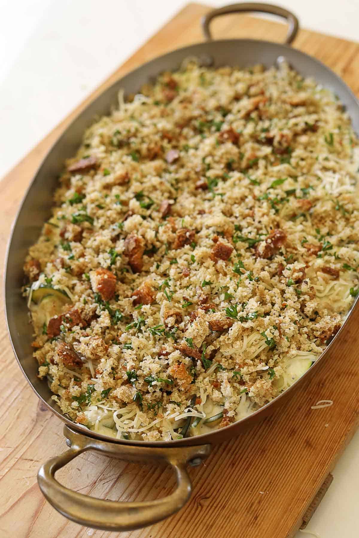 Zucchini gratin in a casserole pan topped with breadcrumbs.