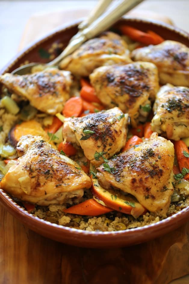 a vertical image of roasted chicken thighs on a bed of couscous