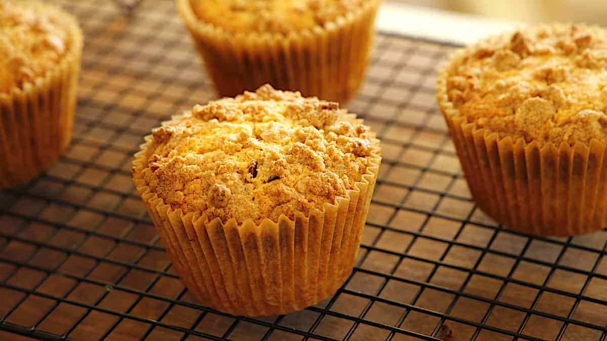 Crumb cake muffins on a cooling rack before powdered sugar