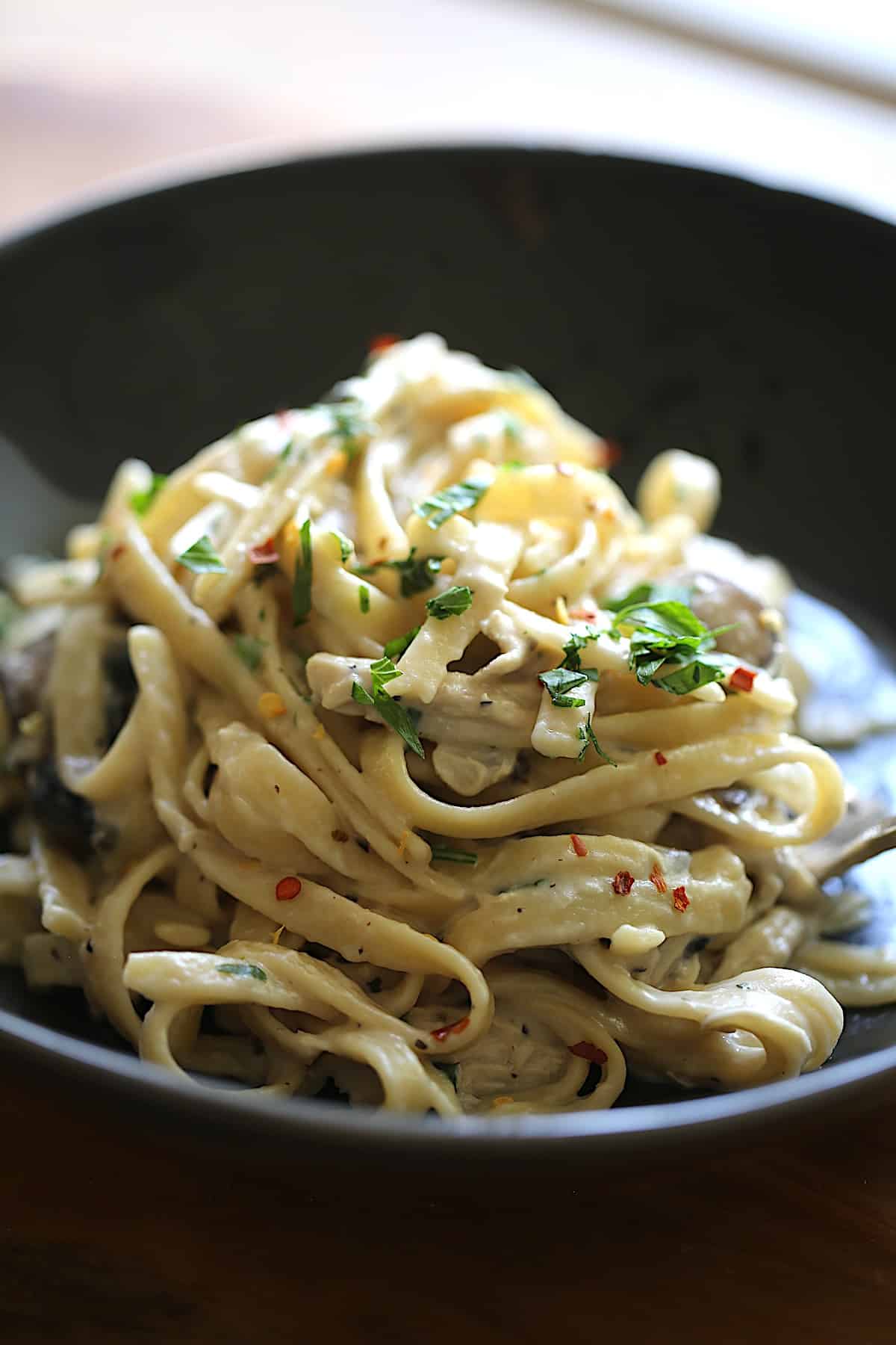 a vertical image of a bowl of Chicken Fettuccini Alfredo 