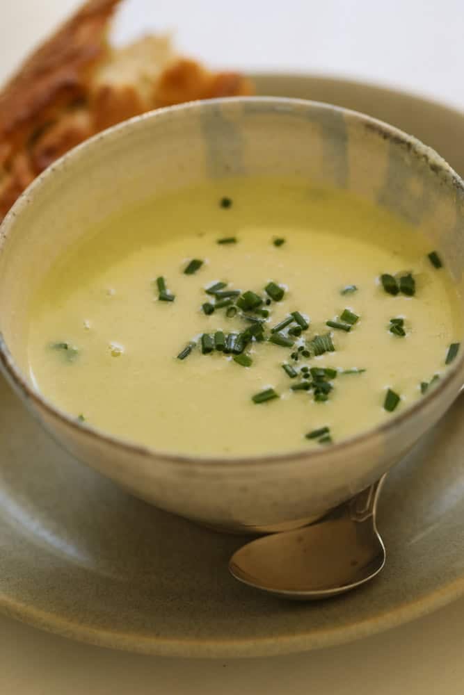 Cream of celery soup in a bowl with bread.