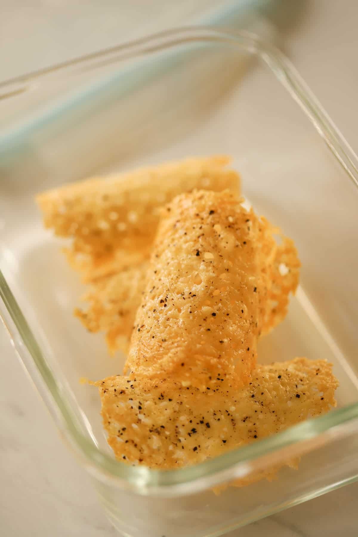 Parmesan tuiles in an airtight storage container.