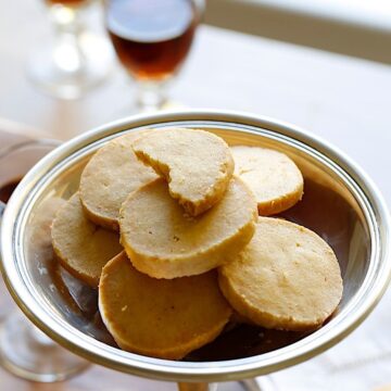 Cheddar CHeese Coins in a Silver Dish with a glass of port in the background