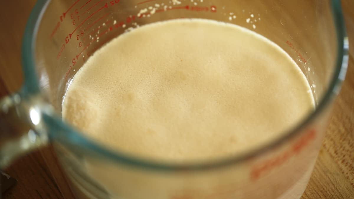 a glass pitcher filled with water and foamy yeast
