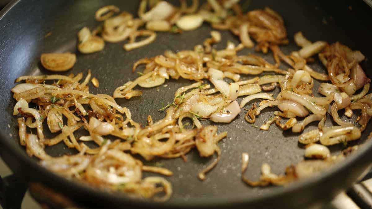 a non-stick skillet filled with caramelized shallots and thyme