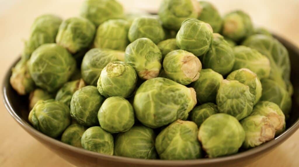 a bowl of Brussels sprouts on a cutting board