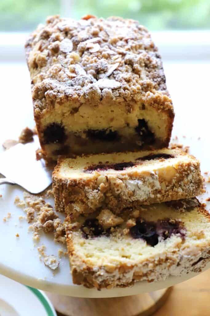 a sliced sour cherry crumb cake on a cake stand showing interior texture