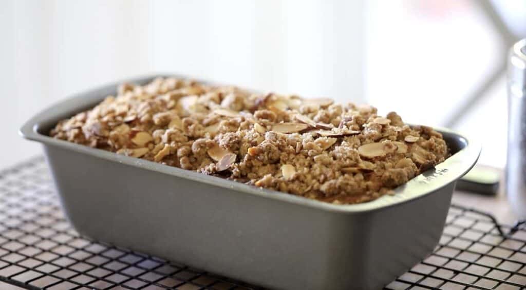 a crumb cake with sour cherries cooling on a rack