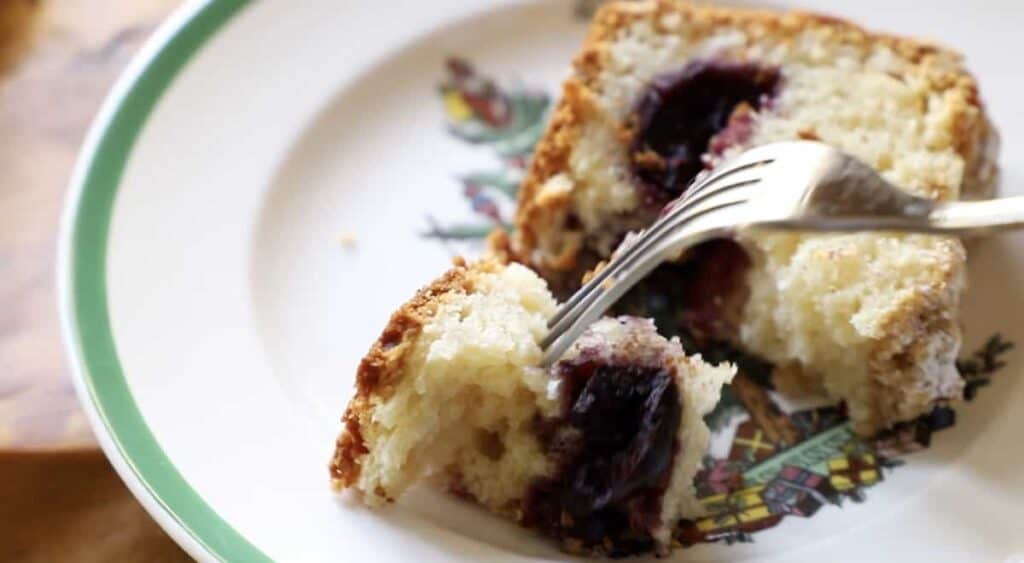 a fork taking a bite of cake on a plate