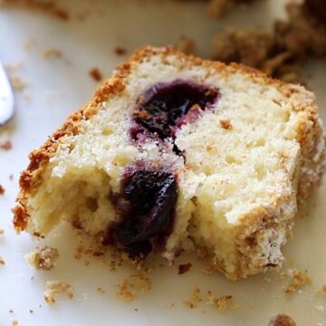 A slice of crumb cake with cherries baked inside