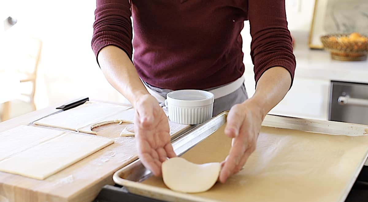 placing pastry round on a parchment lined cookie sheet