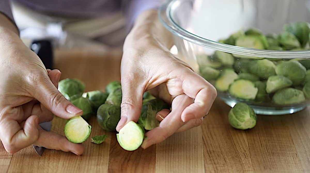 a person showing a brussel sprout cut in half