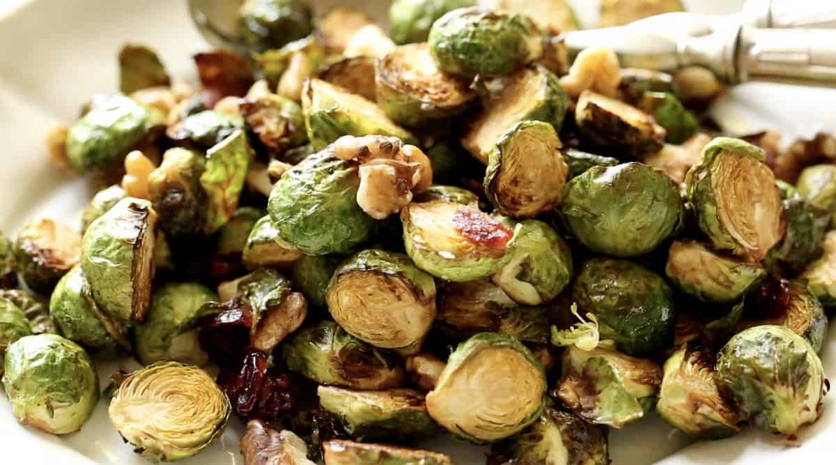 detail of brussel sprouts on a platter with buts and dried cranberries