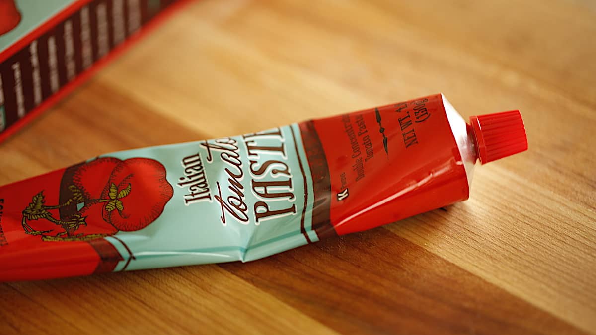 a tube of tomato paste on a cutting board