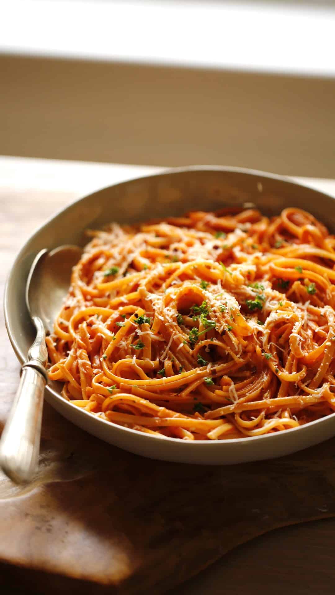 A bowl of linguine in tomato cream sauce.