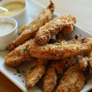 Chicken tenders on a platter with dipping sauces