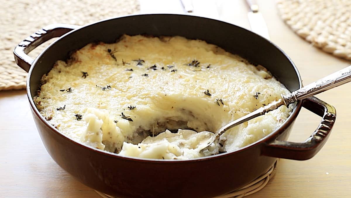 Hachis Parmentier in a round casserole with a serving spoon 