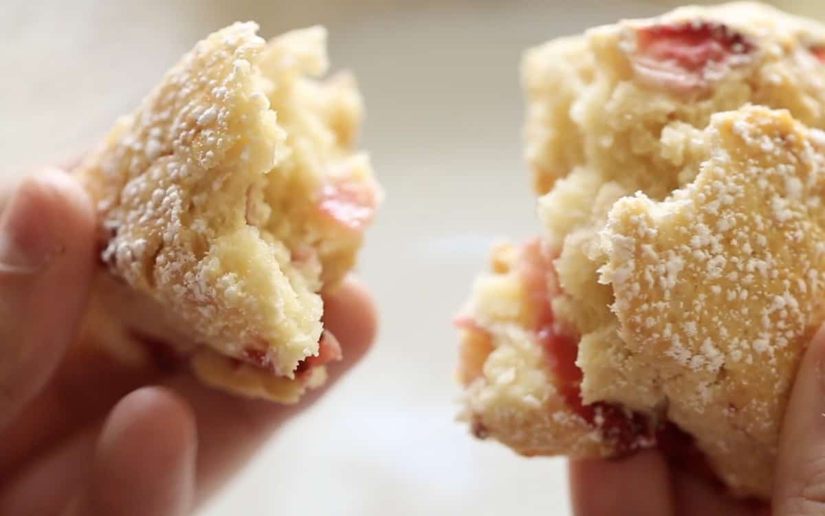 a person splitting a scone in half to show the flakey texture