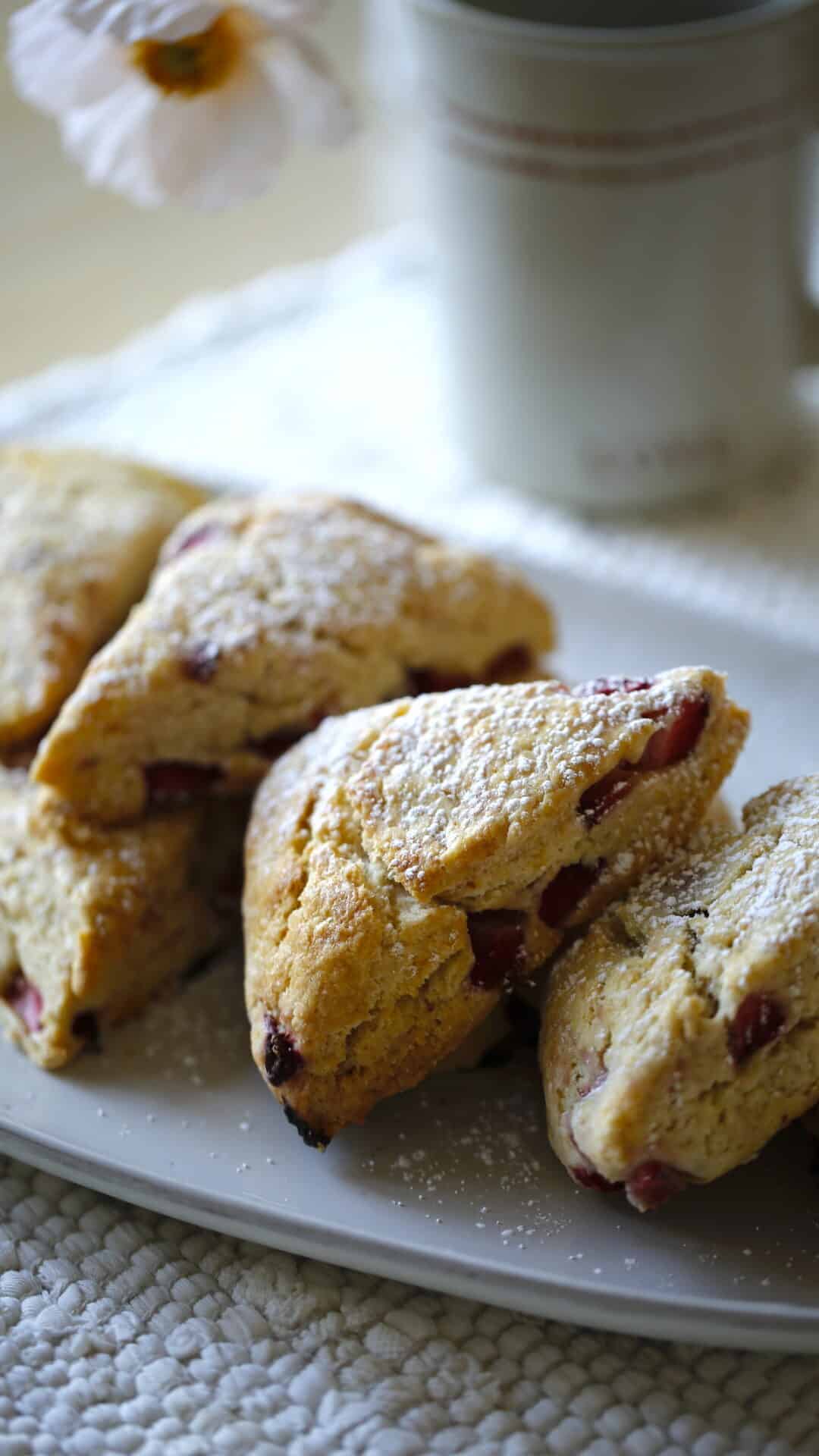 Strawberry Scones on a platter with a coffee mug in the background