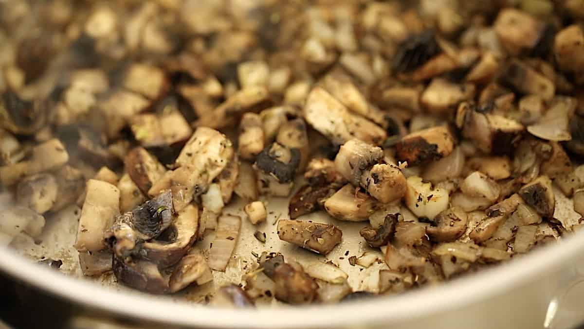 Mushrooms sautéing in a pan 