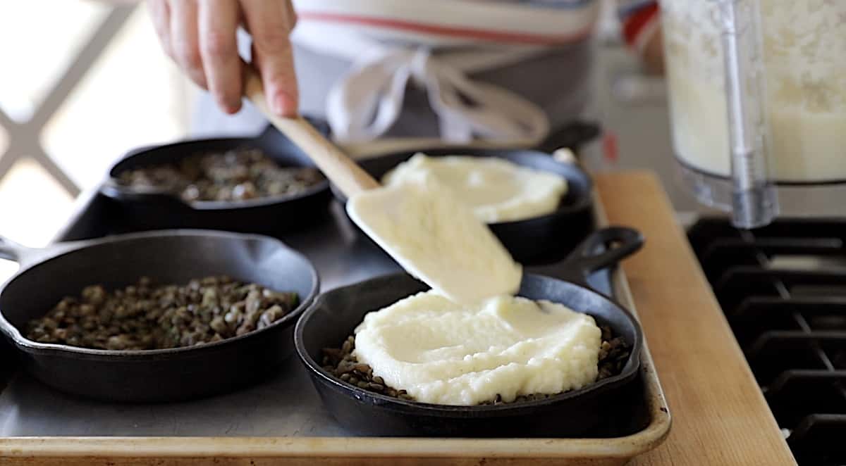 covering lentil and mushroom mixture with cauliflower mash