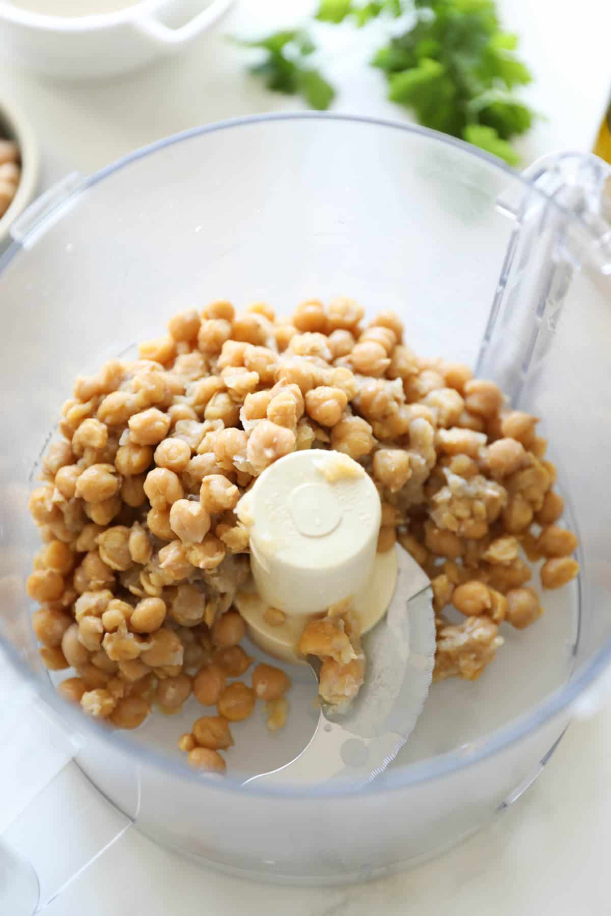 Chickpeas soften with skins peeling in a food processor