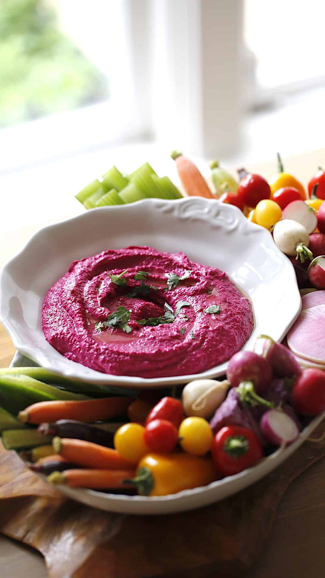 Beet Hummus in a white bowl with Vegetables